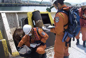 津波により座礁した貨物船の調査を行う機動防除隊員(平成23年5月26日、福島県原町火力発電所前)