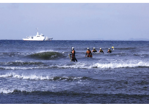 海岸付近を捜索する潜水士と巡視船